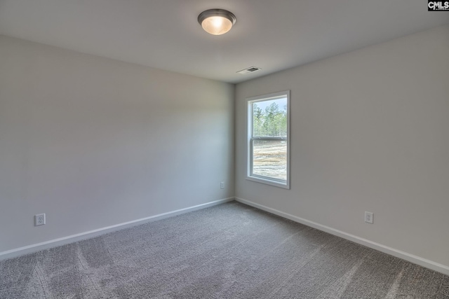 carpeted spare room with visible vents and baseboards