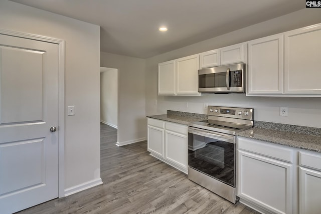 kitchen with light wood-style flooring, recessed lighting, stainless steel appliances, baseboards, and white cabinets