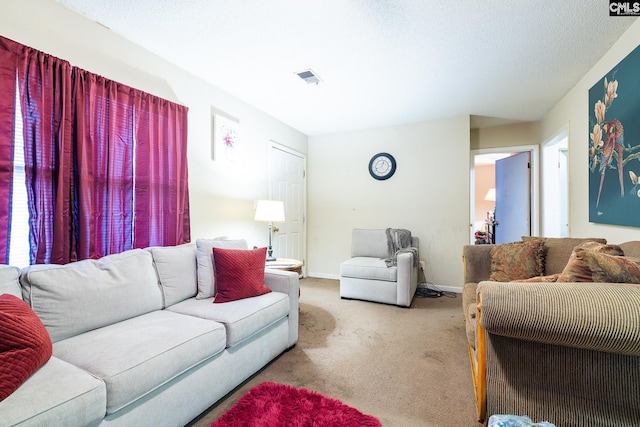 living room featuring light colored carpet, visible vents, a textured ceiling, and baseboards