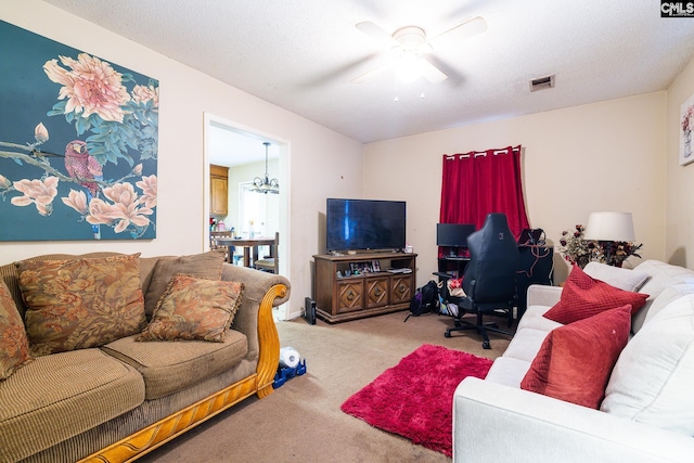 living room featuring light carpet, a textured ceiling, ceiling fan with notable chandelier, and visible vents