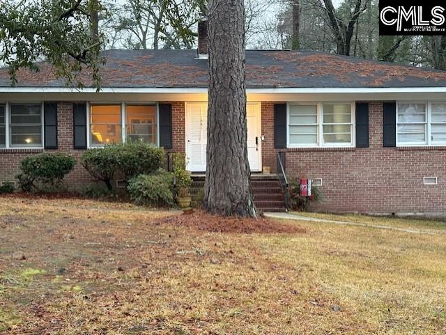 single story home featuring crawl space, brick siding, a chimney, and a front lawn