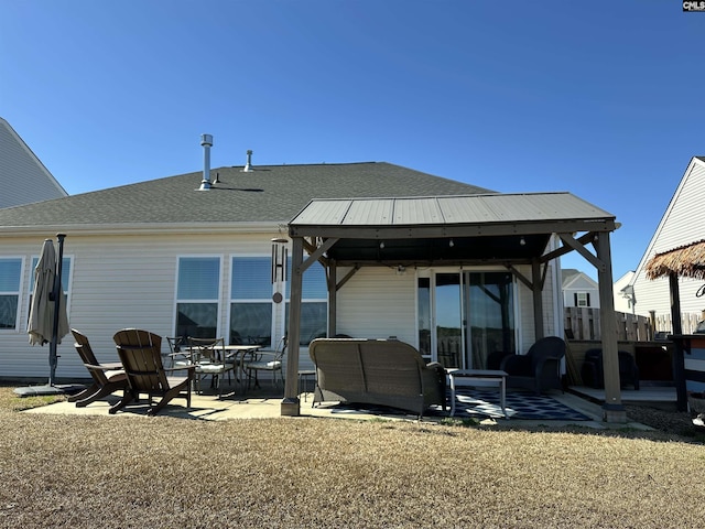 back of property featuring a shingled roof, a patio area, a lawn, and outdoor lounge area