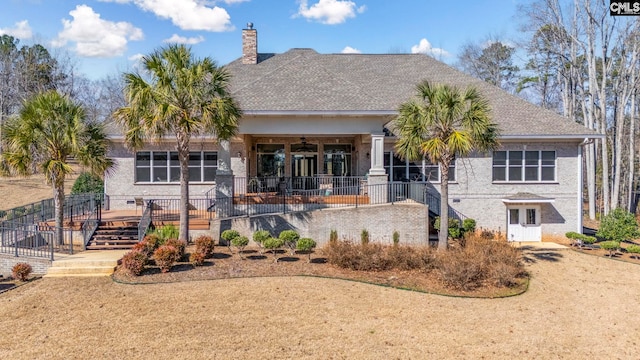 back of property featuring stairs, roof with shingles, a chimney, and a ceiling fan