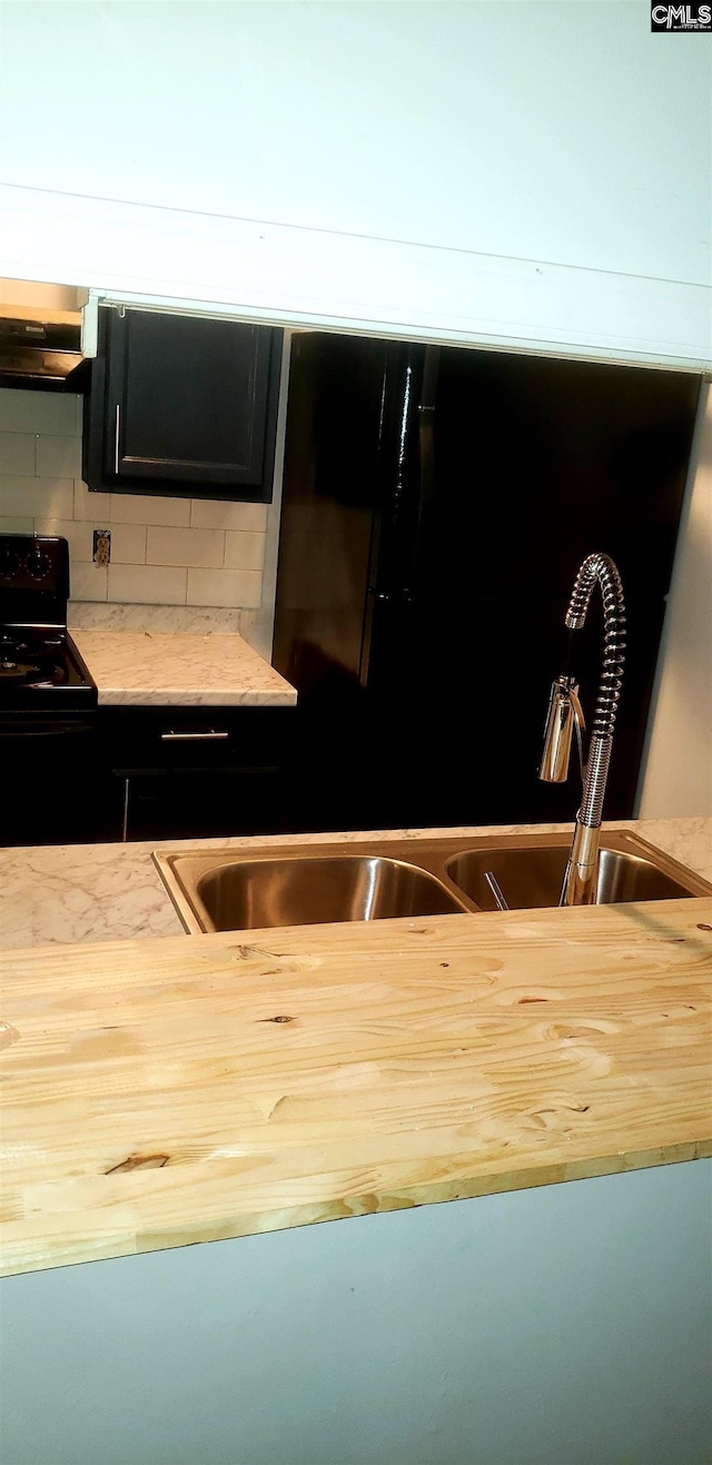 kitchen with light countertops, backsplash, a sink, ventilation hood, and black range with electric cooktop