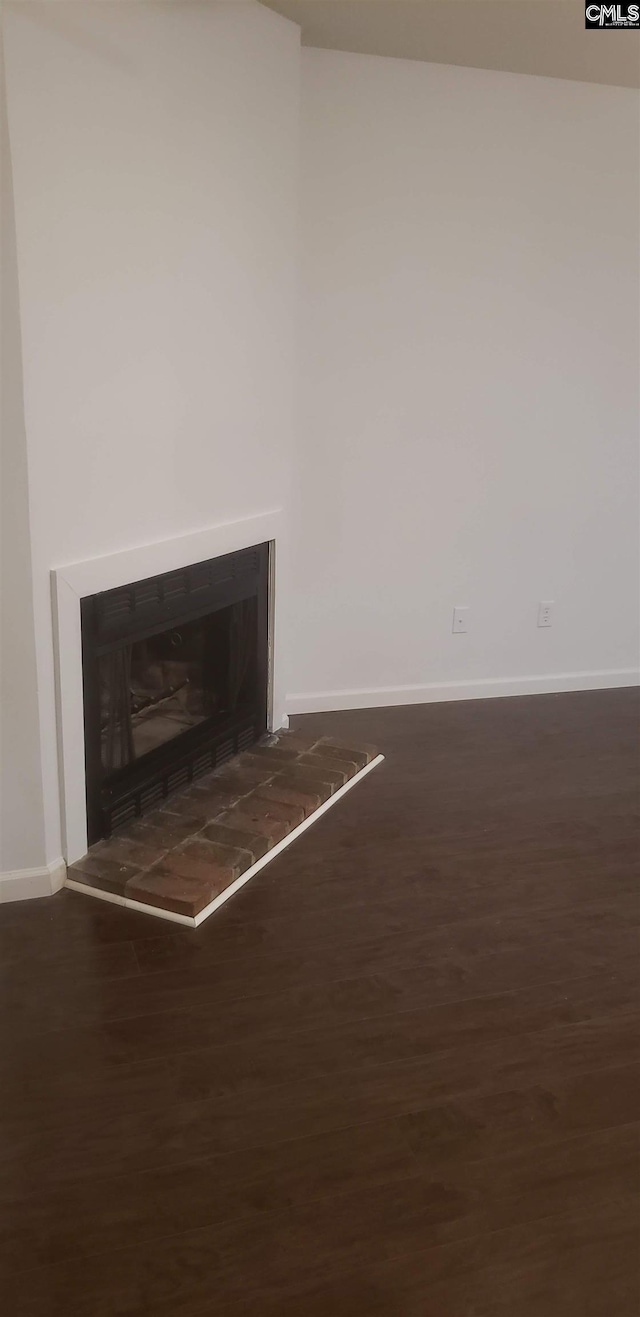 room details with a tiled fireplace, wood finished floors, and baseboards