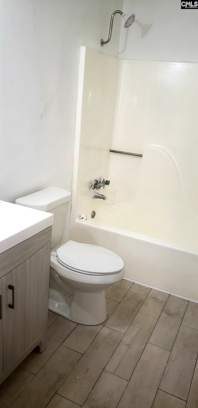 full bath with vanity, wood finish floors, shower / tub combination, and toilet