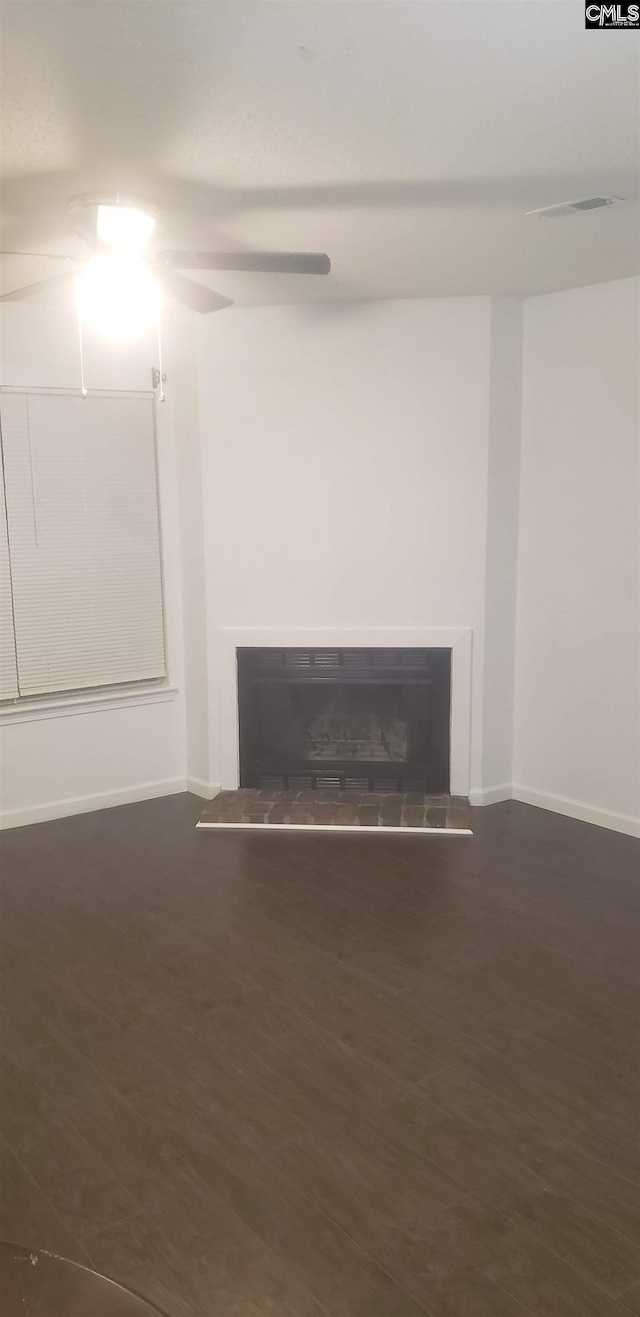 details featuring baseboards, a tiled fireplace, and wood finished floors