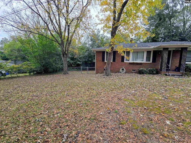 view of front facade with crawl space, fence, and brick siding