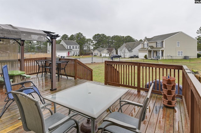 deck with outdoor dining space, a residential view, a lawn, and a pergola