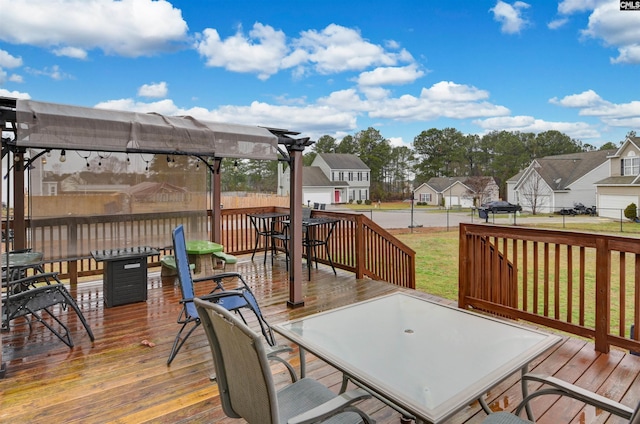 wooden deck with a yard, outdoor dining space, a residential view, and a pergola