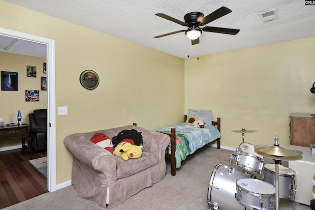 bedroom with a textured ceiling, carpet floors, visible vents, and baseboards