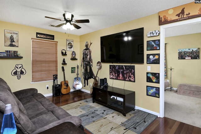 living area featuring ceiling fan, a textured ceiling, baseboards, and wood finished floors