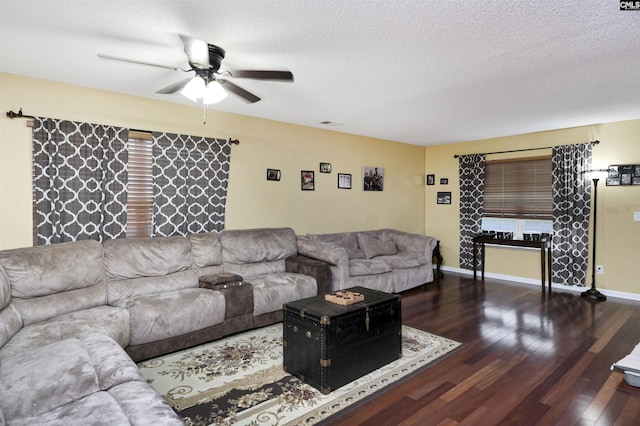 living room featuring dark wood-style floors, ceiling fan, a textured ceiling, and baseboards