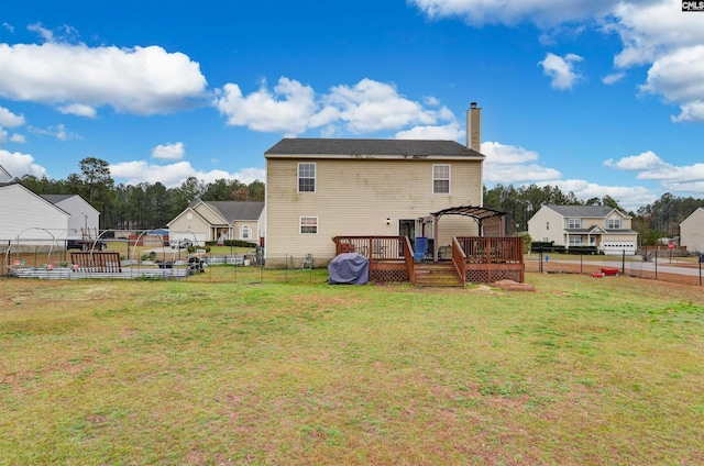 rear view of property featuring a fenced backyard, a chimney, a deck, a yard, and a pergola