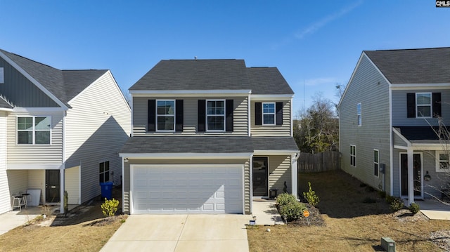 view of front of property featuring a garage, driveway, a shingled roof, and fence