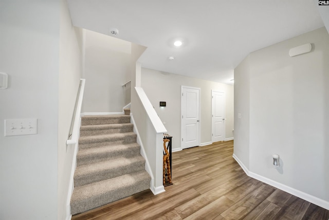 stairs with baseboards and wood finished floors