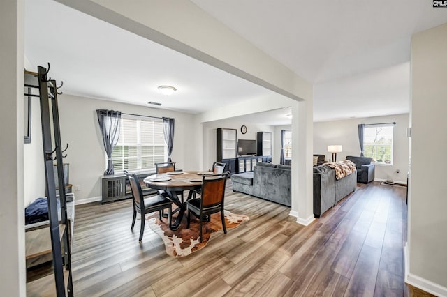 dining space with visible vents, baseboards, and wood finished floors