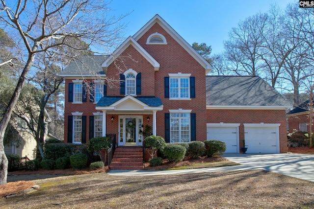 view of front of home with driveway, brick siding, roof with shingles, and an attached garage