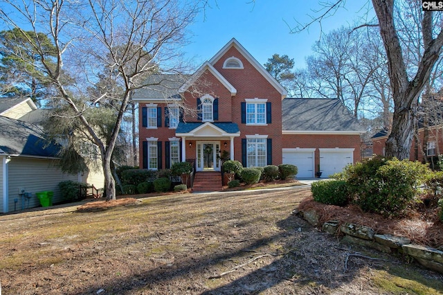 colonial house featuring brick siding and an attached garage