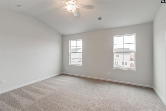 empty room with visible vents, a ceiling fan, carpet flooring, vaulted ceiling, and baseboards