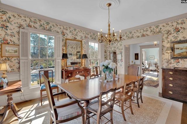 dining area with wallpapered walls, ornamental molding, light wood-style floors, and a notable chandelier