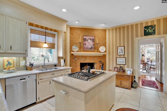 kitchen with hanging light fixtures, appliances with stainless steel finishes, a sink, and a center island