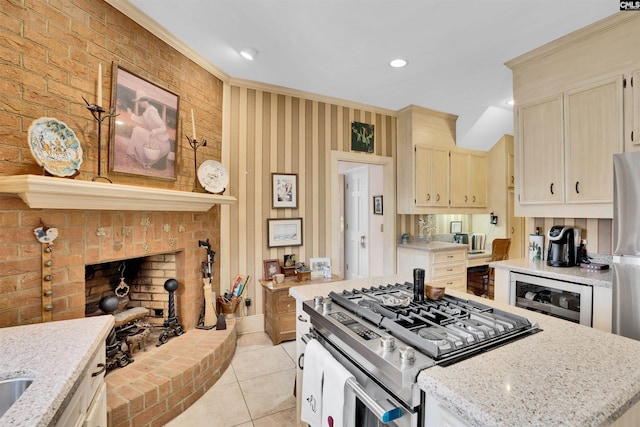 kitchen featuring light stone counters, a brick fireplace, beverage cooler, and gas range