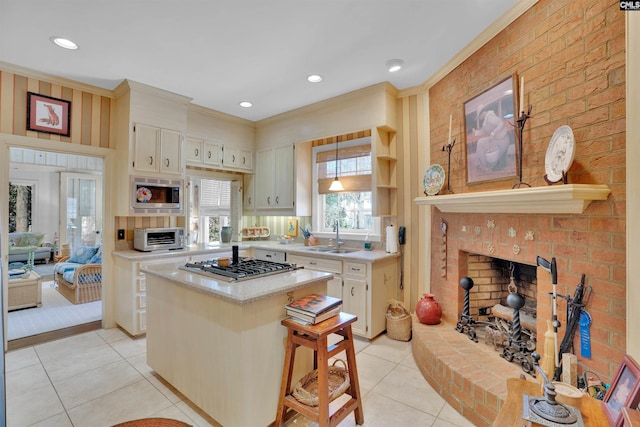 kitchen with a fireplace, light countertops, appliances with stainless steel finishes, a kitchen island, and a kitchen breakfast bar