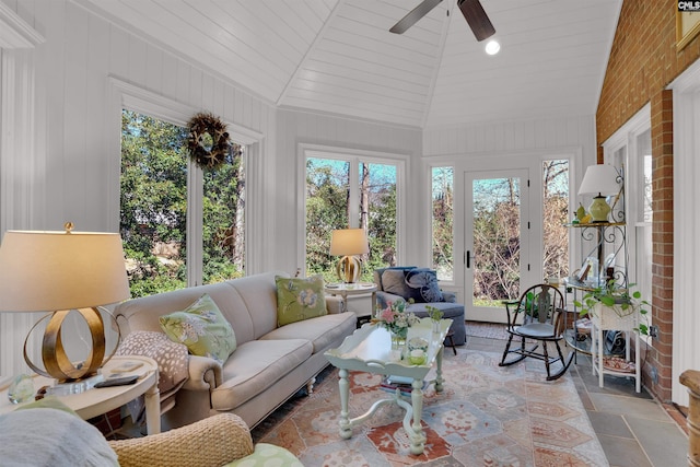 sunroom featuring a ceiling fan, a healthy amount of sunlight, and vaulted ceiling