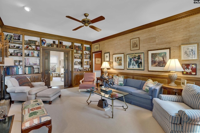 living room with light carpet, ornamental molding, a ceiling fan, and built in features