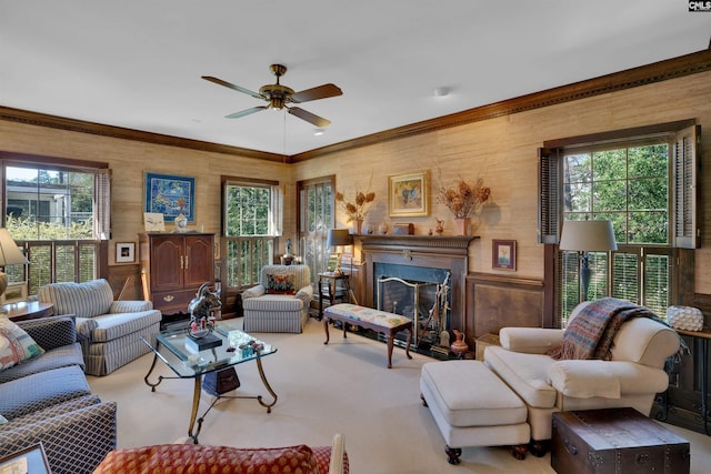 carpeted living area featuring a fireplace, a ceiling fan, and crown molding