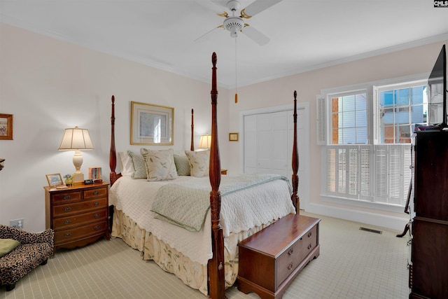 bedroom featuring light carpet, visible vents, a ceiling fan, and ornamental molding