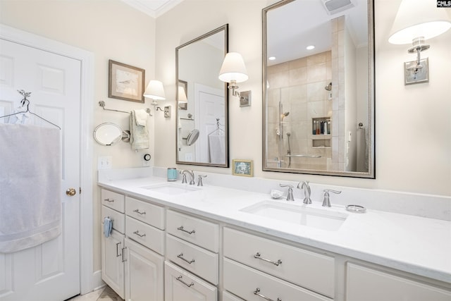 bathroom featuring double vanity, a stall shower, crown molding, and a sink