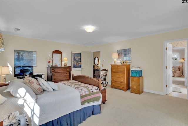 bedroom with light colored carpet and baseboards