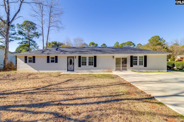 ranch-style home featuring brick siding and a front lawn