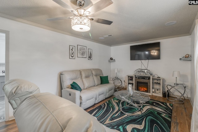 307 Wyoming Dr, Sumter, SC 29153 - living area with a textured ceiling, wood finished floors, visible vents, a lit fireplace, and crown molding