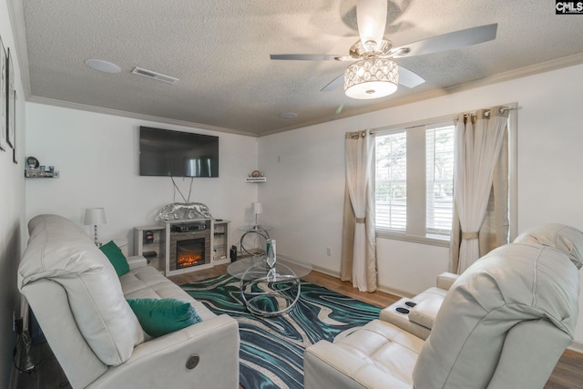 307 Wyoming Dr, Sumter, SC 29153 - living area with a glass covered fireplace, visible vents, crown molding, and wood finished floors
