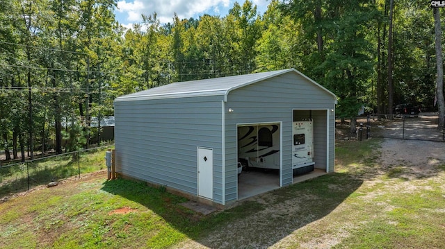 view of outdoor structure featuring fence and an outbuilding