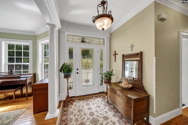 entryway with light wood finished floors, decorative columns, ornamental molding, and baseboards