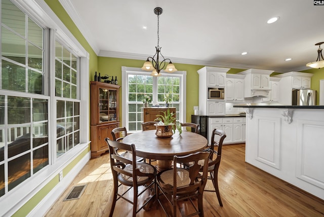 dining room with light wood finished floors, ornamental molding, visible vents, and recessed lighting