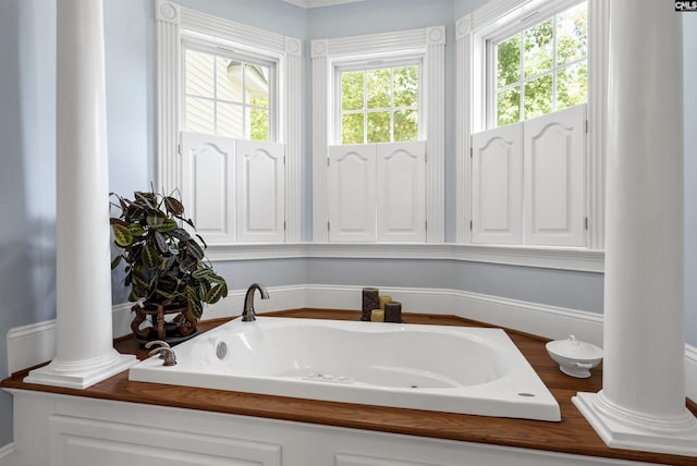 bathroom featuring a bath and ornate columns