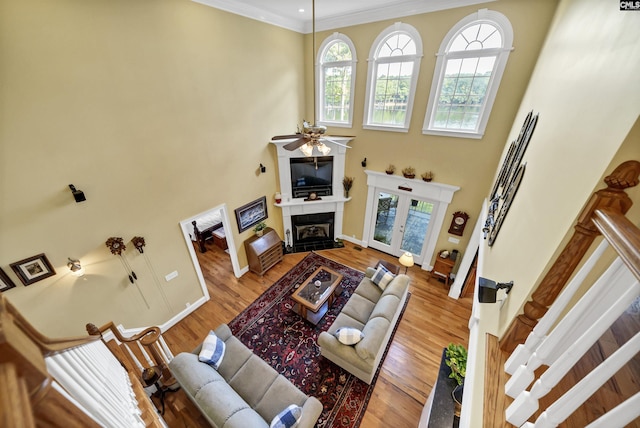 living room with wood finished floors, a fireplace with flush hearth, a wealth of natural light, and a ceiling fan