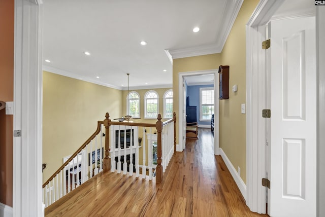 corridor featuring recessed lighting, an upstairs landing, baseboards, light wood-style floors, and crown molding