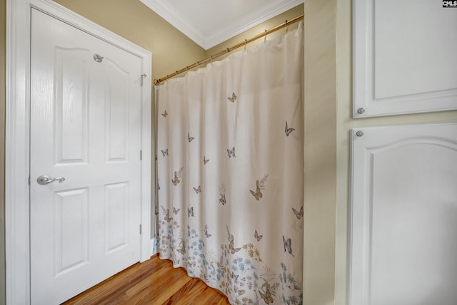 bathroom with crown molding and wood finished floors