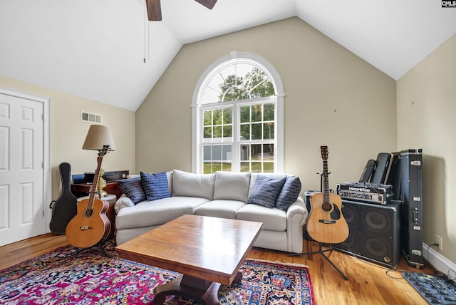 living room featuring a ceiling fan, visible vents, vaulted ceiling, and wood finished floors