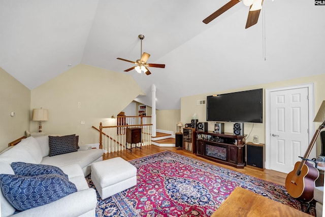 living area with vaulted ceiling, ceiling fan, and wood finished floors