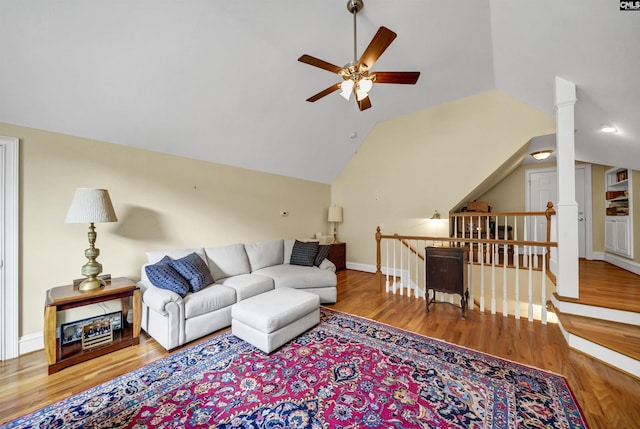 living area featuring lofted ceiling, wood finished floors, a ceiling fan, and baseboards