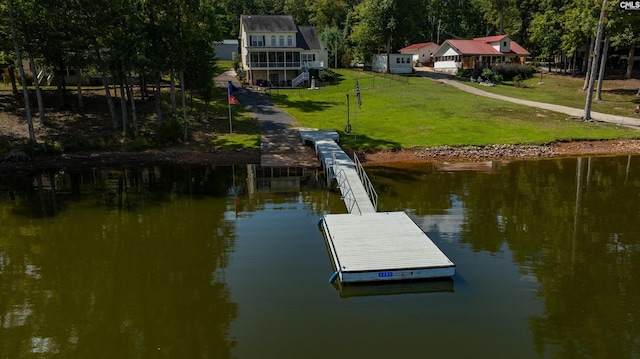 view of dock with a water view and a lawn