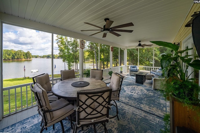 sunroom featuring a water view