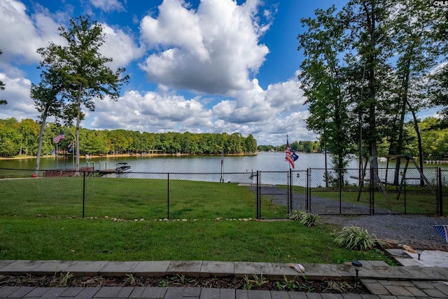 view of community with a water view, a gate, fence, and a lawn